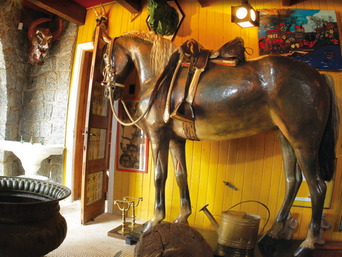 O cavalo de Temuco, restaurado por presentes de amigos do poeta. Neruda dizia que era o único cavalo do mundo com rabo de três cores. A porta à esquerda, acima, é de um pequeno banheiro "só para homens" e decorado com postais eróticos antigos.