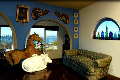 Sala de estar do terceiro andar de La Sebastiana. A vaca de porcelana no centro da mesa era usada por Neruda para servir ponches a seus convidados.